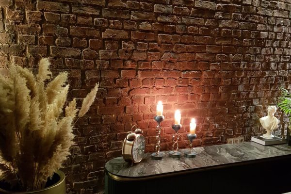 Heritage Faux Brick Wall Panel M267 Fake distressed red brick wall in a candle lit room