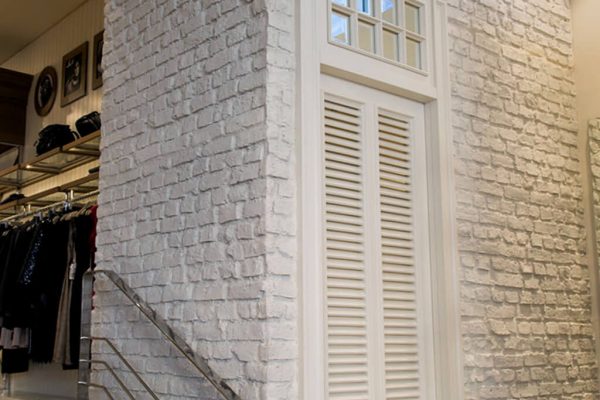 Heritage Faux Brick Wall Panel White Washed M261 A white brick wall within a retail shop.